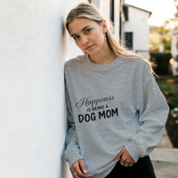 Load image into Gallery viewer, Ash - Happiness Is Being a Dog Mom sweatshirt, worn by a woman leaning on a white wall
