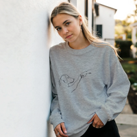 Load image into Gallery viewer, Ash - Dog Fist Bump sweatshirt, worn by a woman leaning on a white wall
