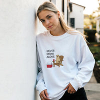 Load image into Gallery viewer, White - Never Drink Alone sweatshirt, worn by a woman leaning on a white wall
